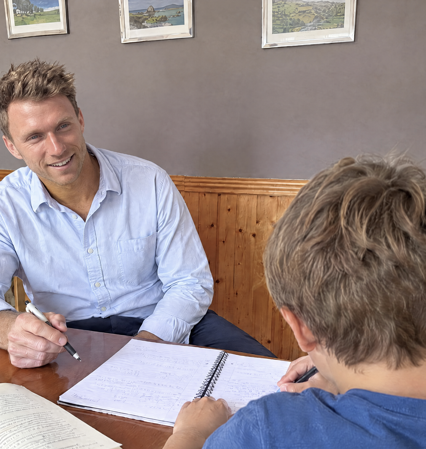 Jack working with a student over an open notebook
